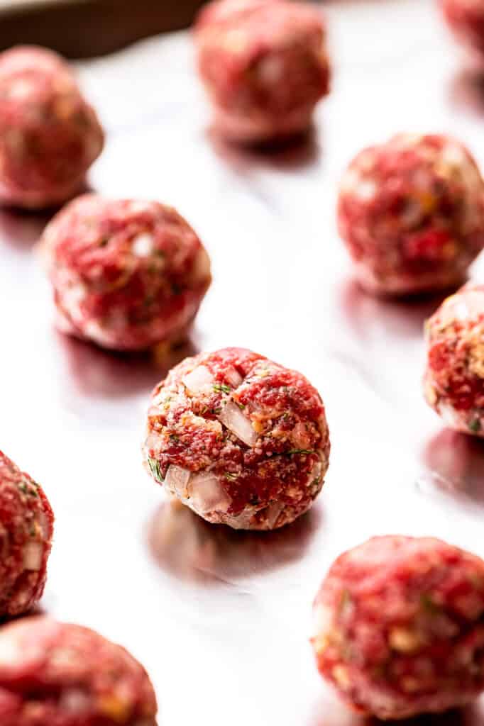 Raw meatballs on baking sheet