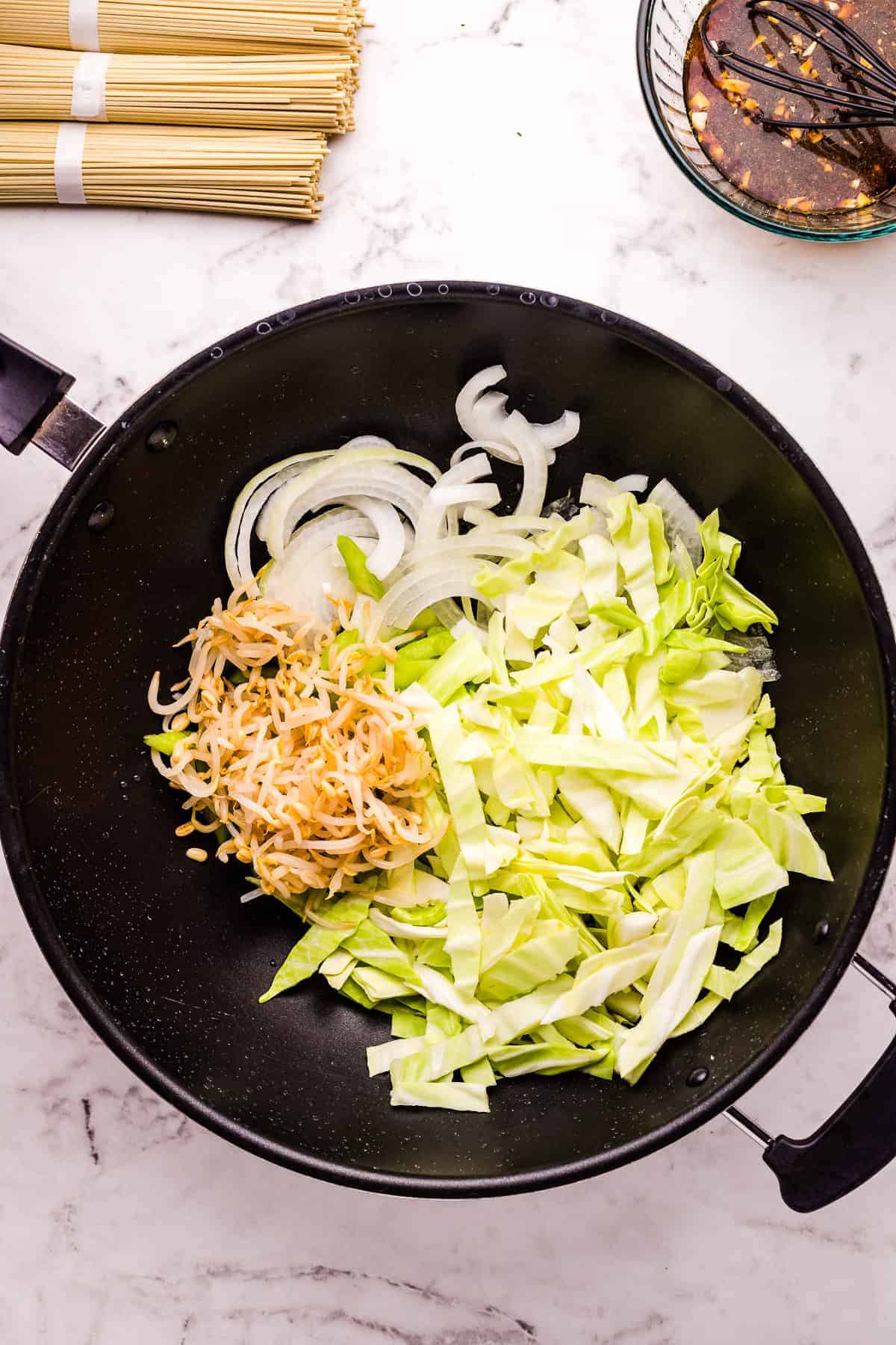 Skillet with celery, onion, cabbage, bean sprouts and sesame oil. 