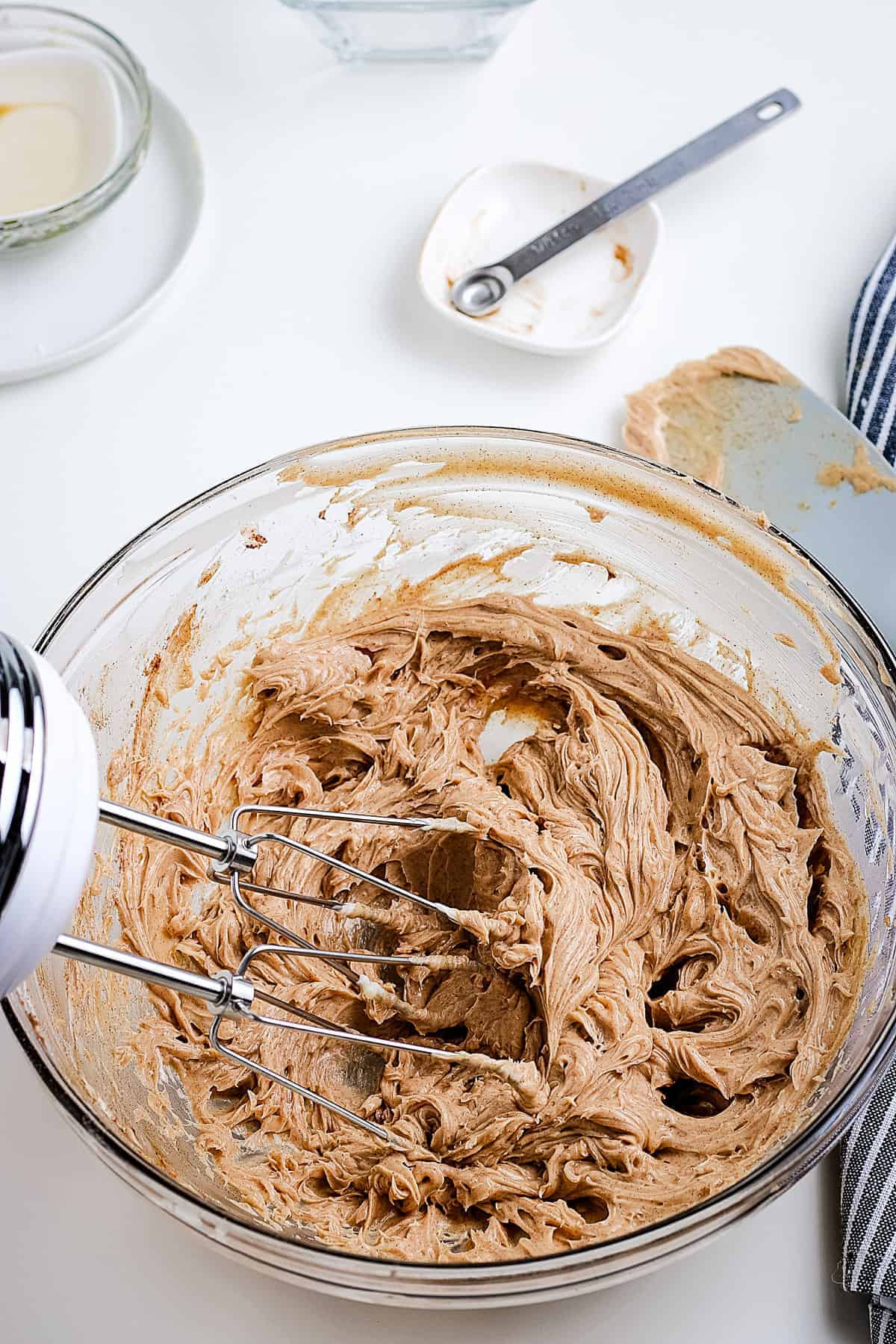 Glass bowl with hand mixer mixing cinnamon butter