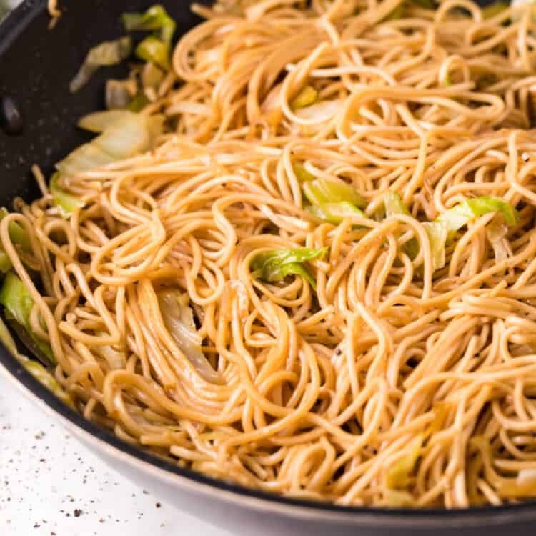 Close up image of chow mein noodles in black skillet
