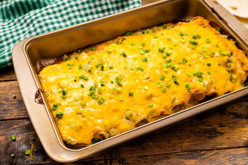 A pan of chicken enchiladas topped with cheese