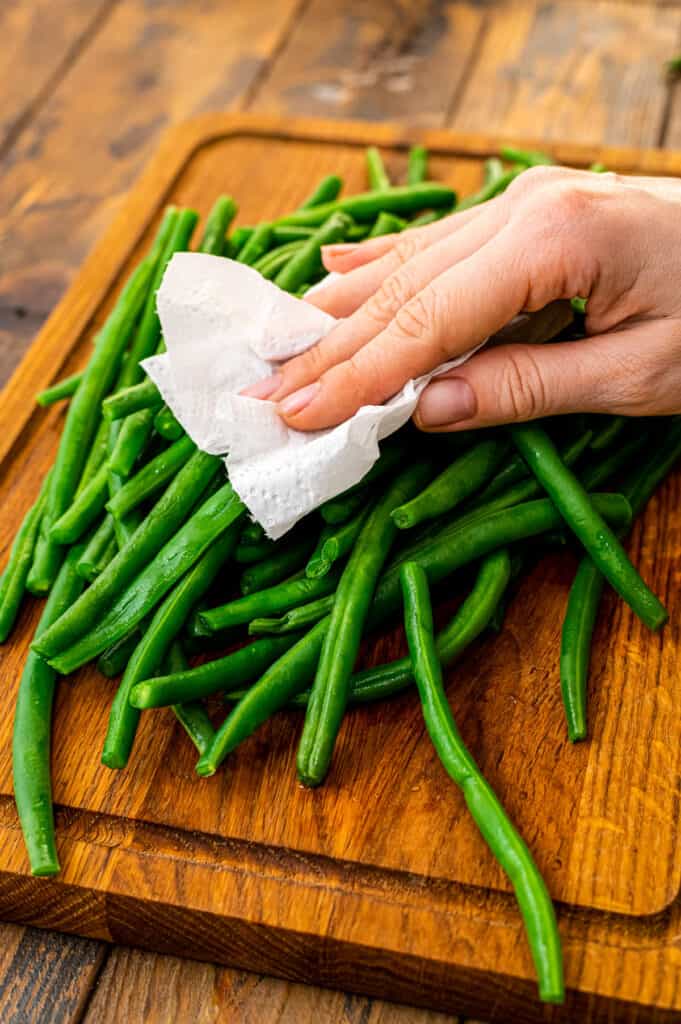 Drying off green beans with paper towel