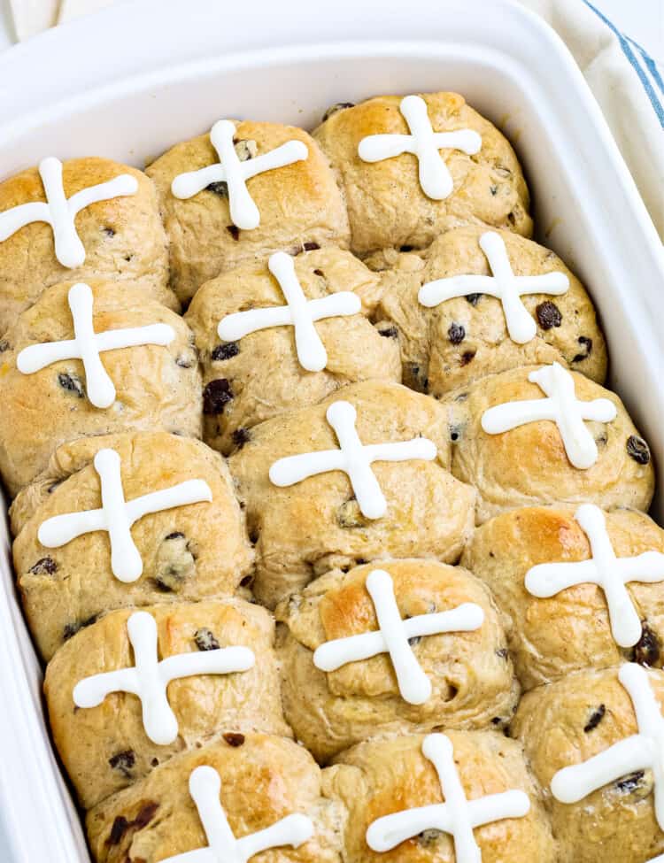 Pan of hot cross buns topped with an icing of a cross