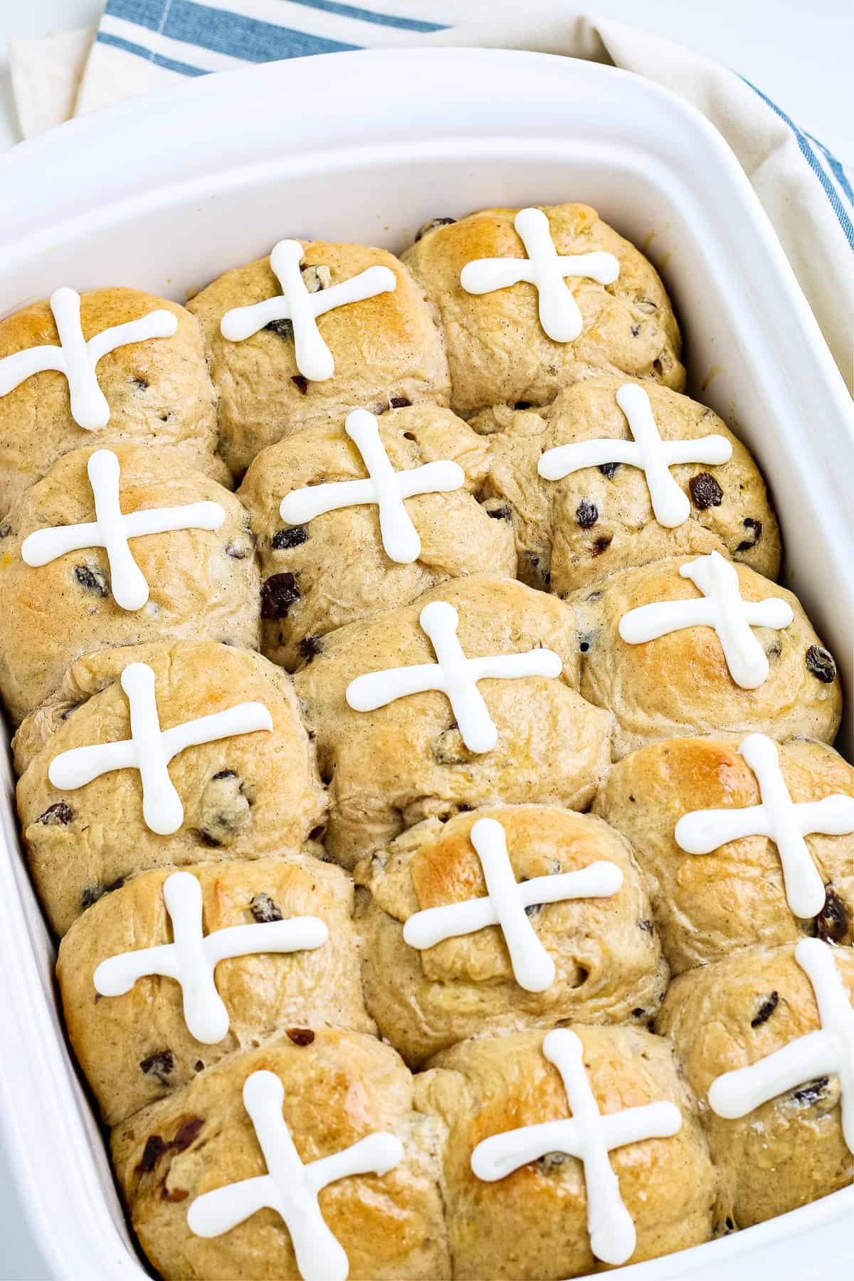 Pan of hot cross buns topped with an icing of a cross