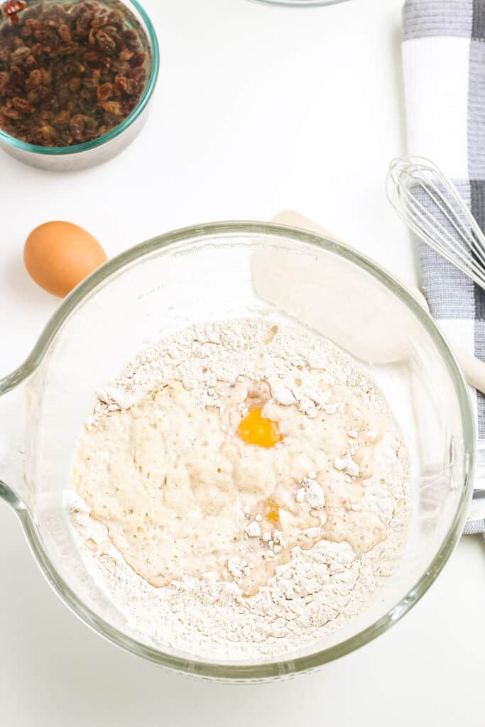 Bowl with flour mixture and eggs and butter to make buns