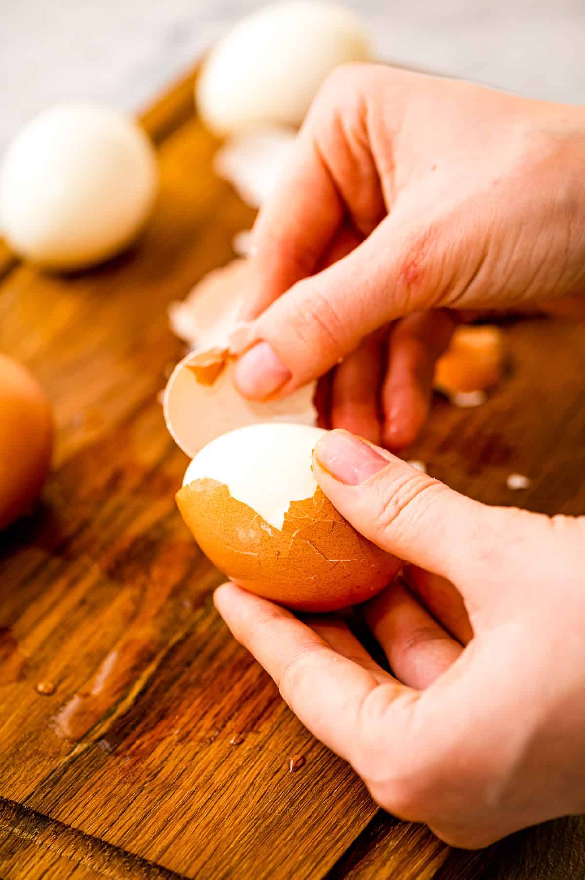 Hands peeling a hard boiled egg