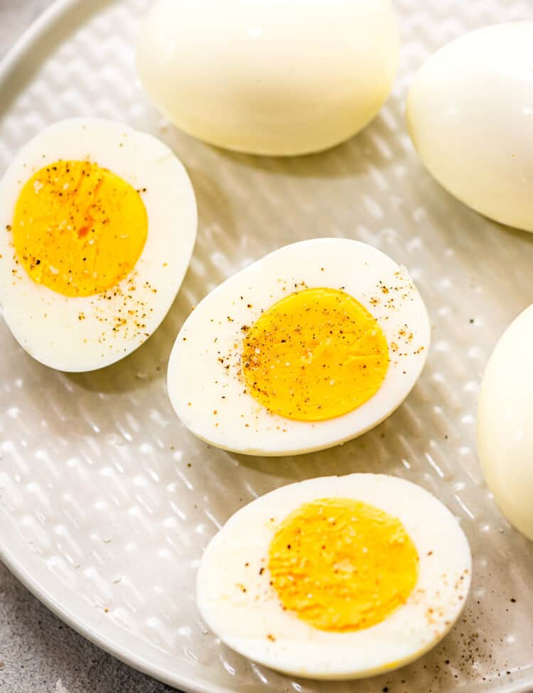 Hard Boiled Eggs cut in half sprinkled with salt and pepper on plate