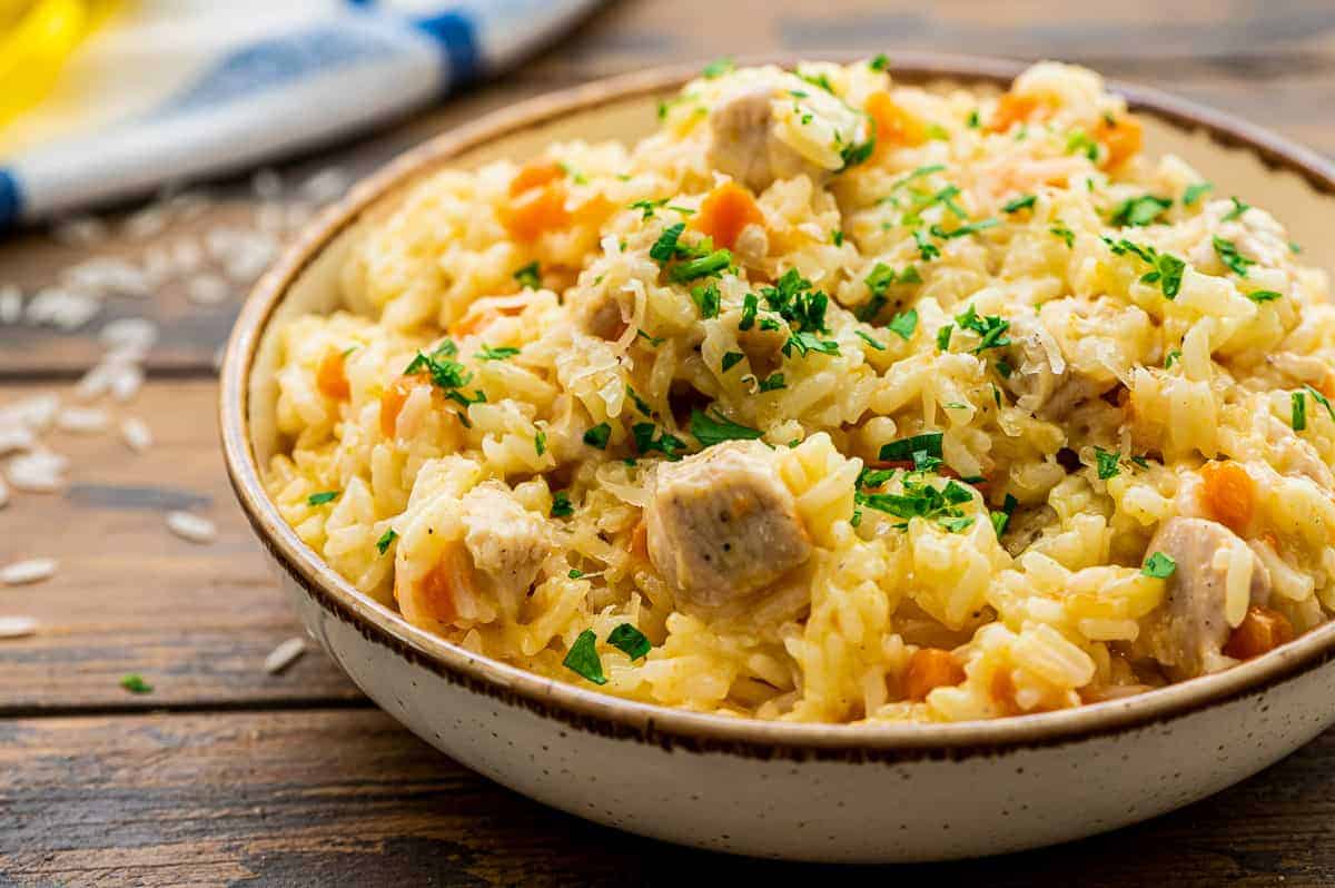 Bowl of chicken and rice topped with chopped parsley