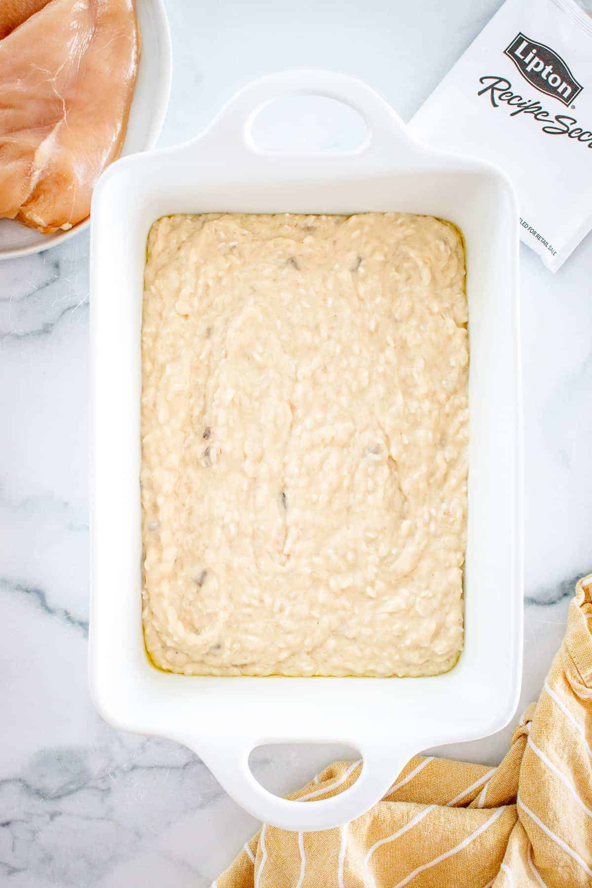 White baking dish with creamy rice mixture on bottom