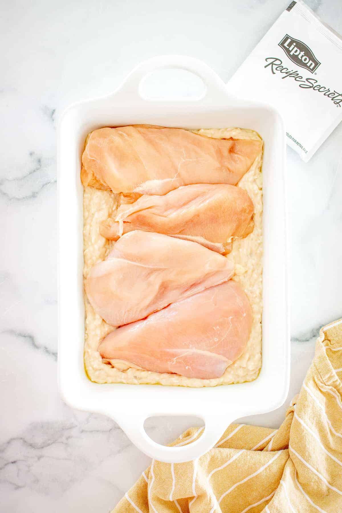 White baking dish with no peek chicken and rice before baking