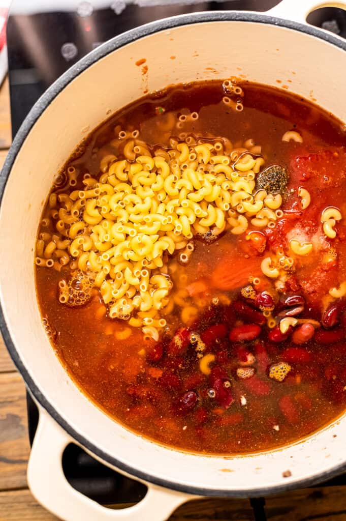 Adding last ingredients to dutch oven for chili mac