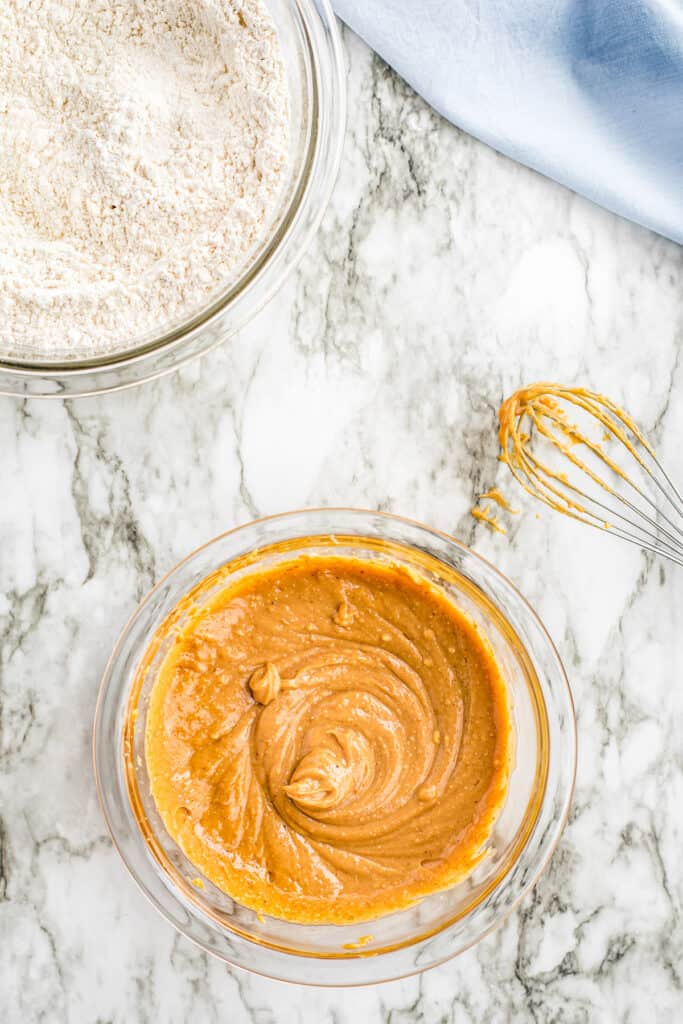 Overhead image of glass bowl with mixed peanut butter mixture for cookies