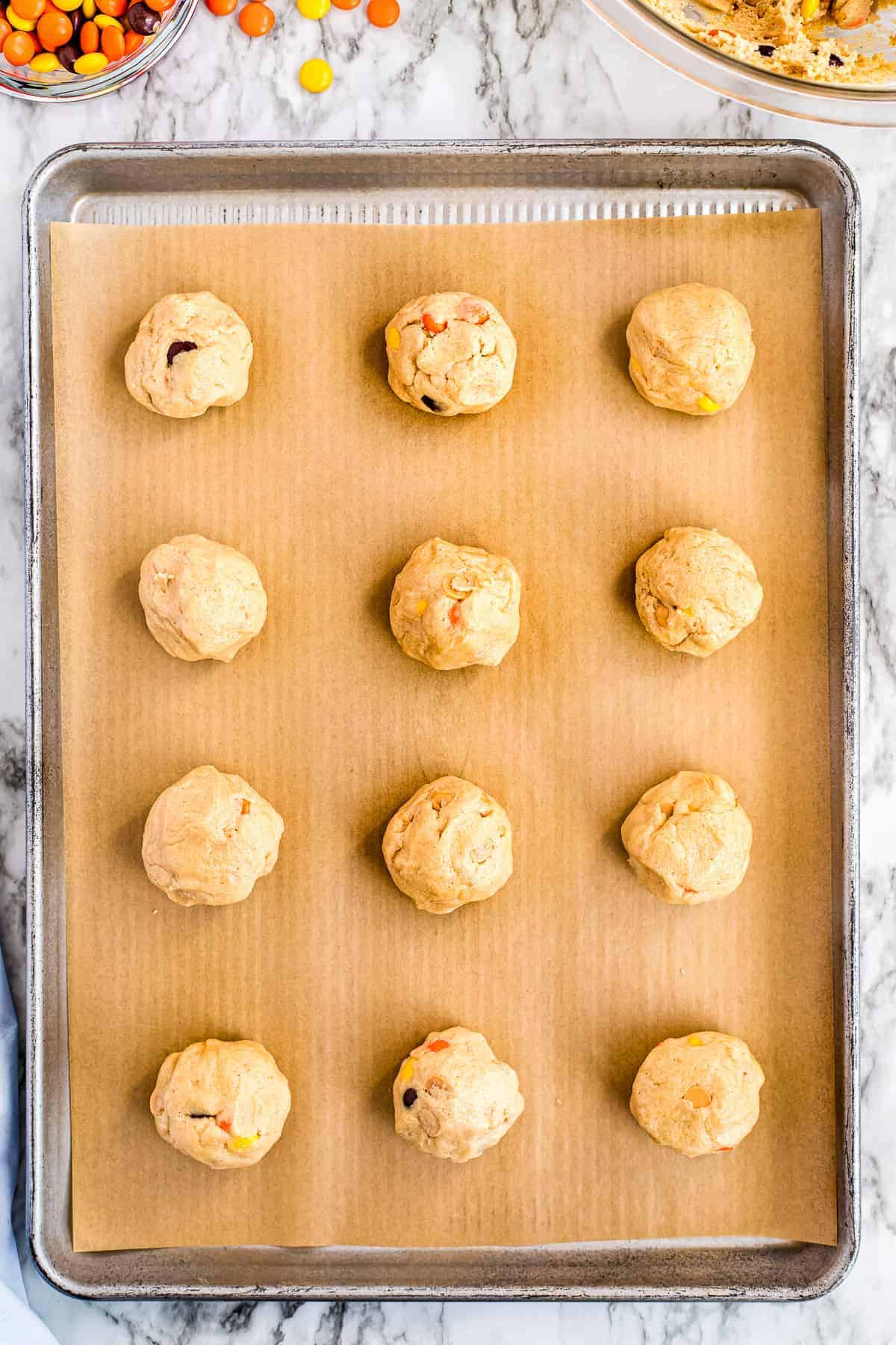 Overhead image of raw cookie dough on baking sheet lined with parchment paper