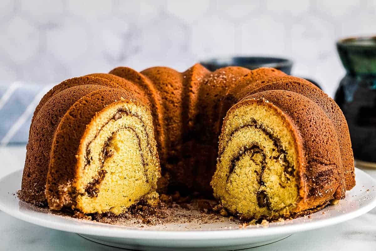 Sour Cream Coffee Cake on white plate with slices taken out of it