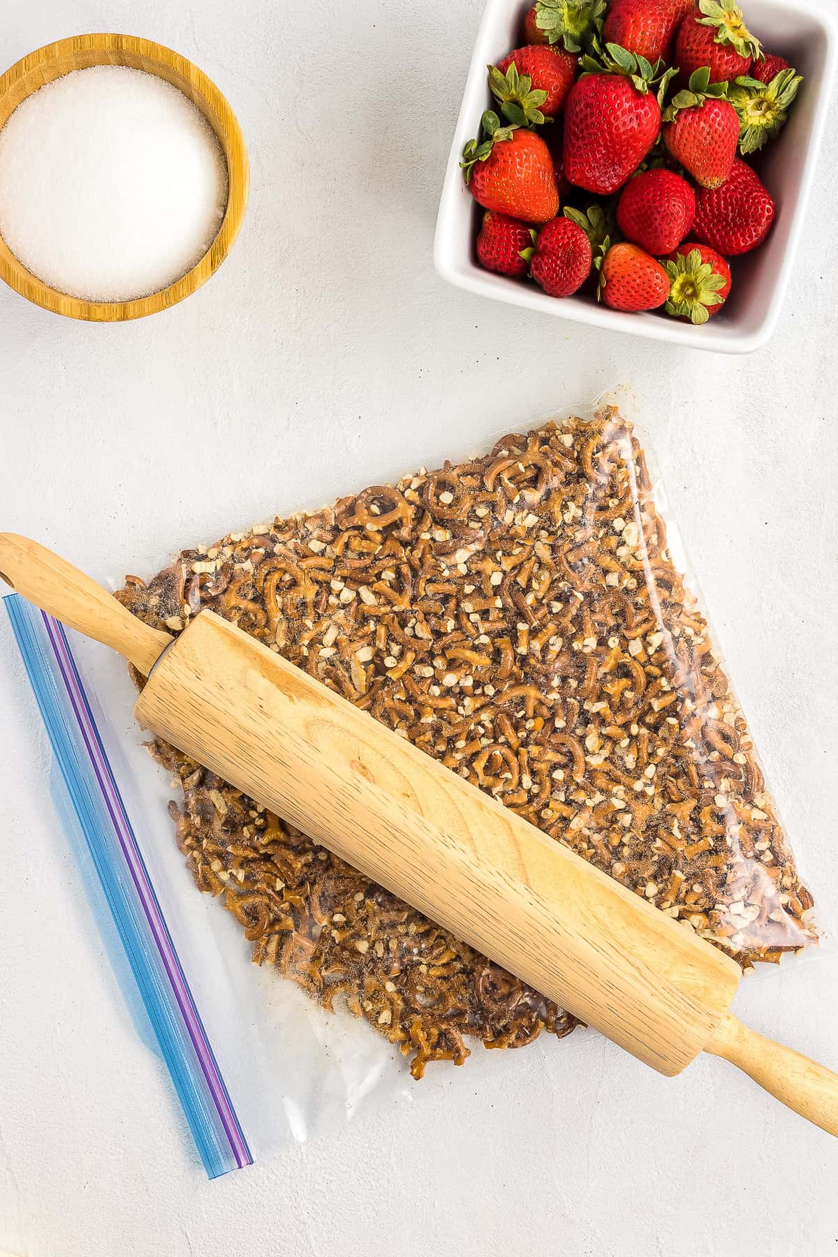 Crushing pretzels in ziploc bag with rolling pin