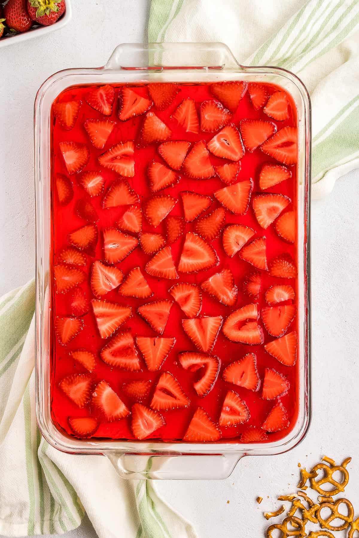 Overhead image of glass pan with strawberry pretzel salad
