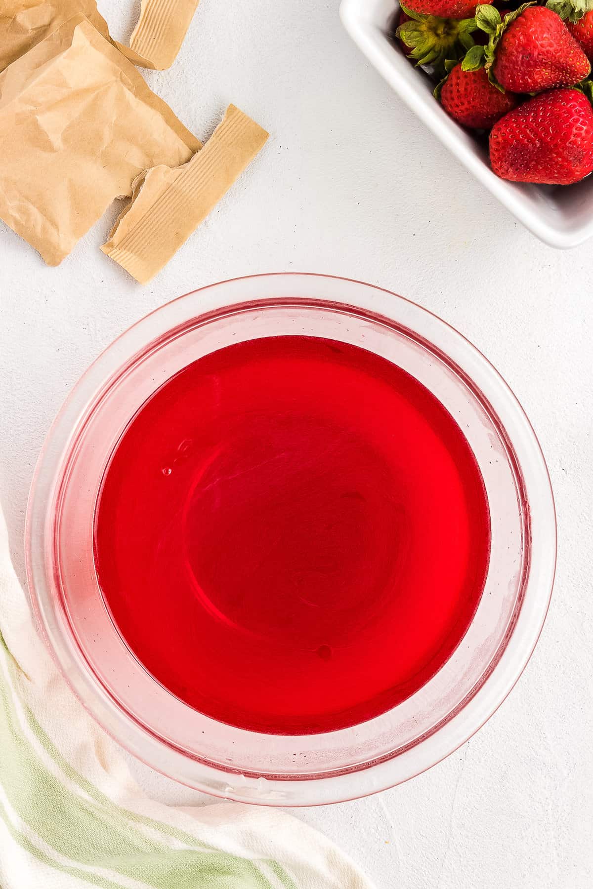 Glass bowl with strawberry jello and water mixed together