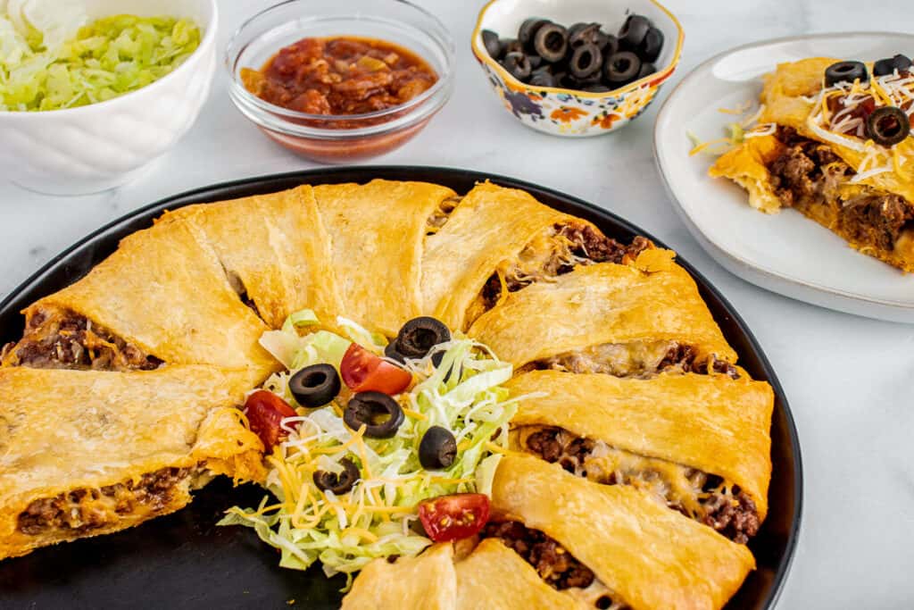 Taco Ring with slice taken out of it on black serving platter