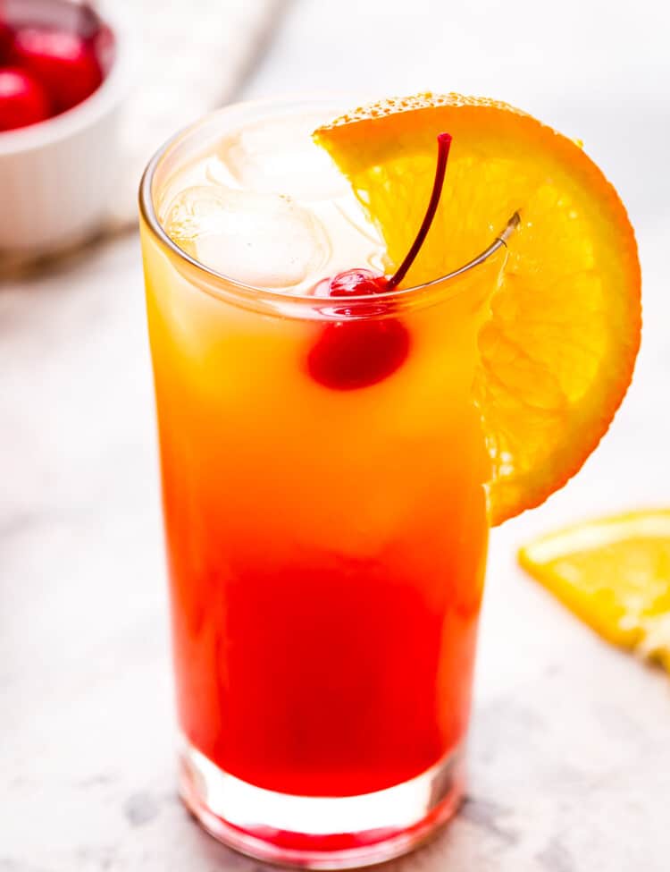 Tequila Sunrise Cocktail in a high ball glass with orange slice garnish