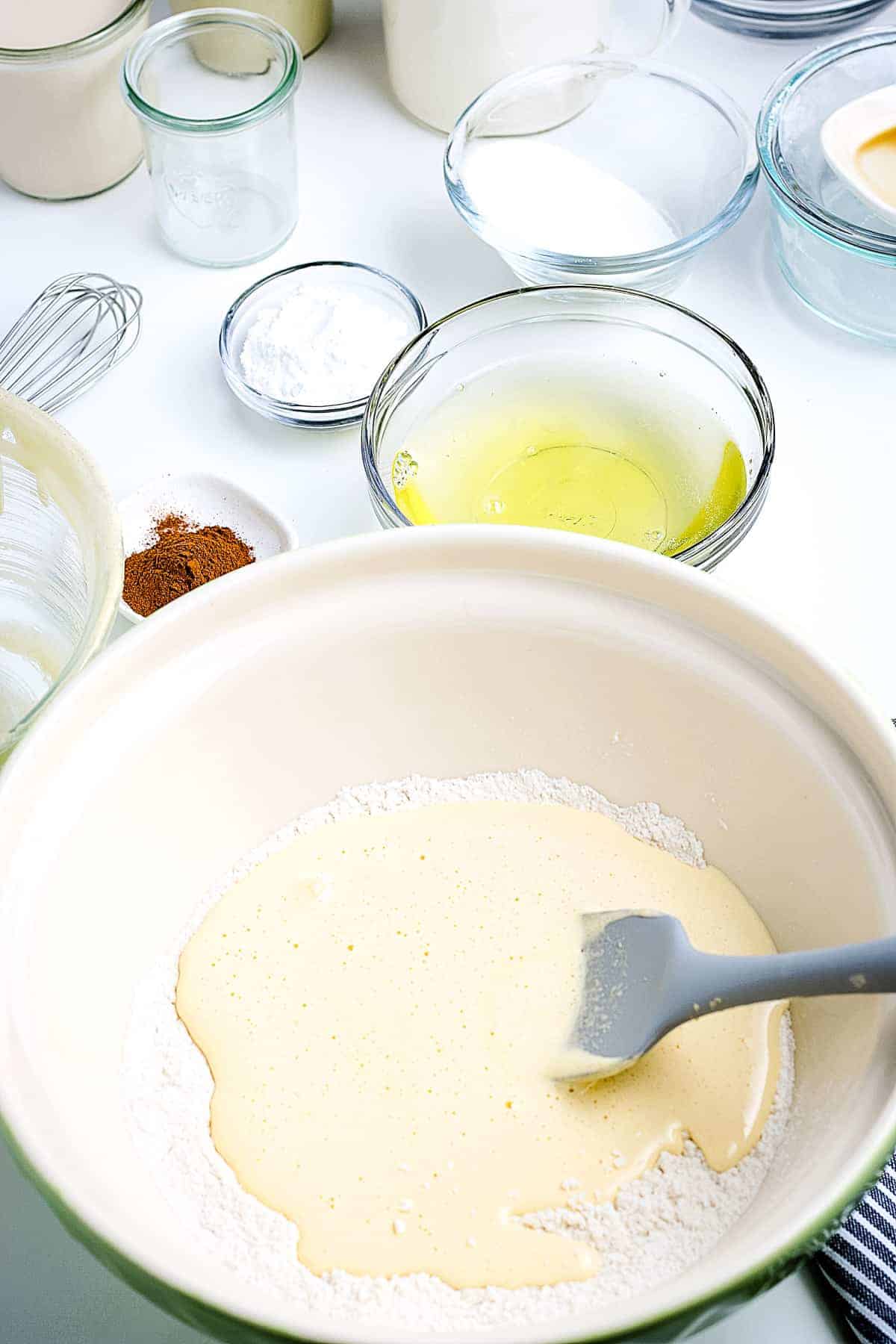 Egg mixture added to flour mixture in bowl before stirring