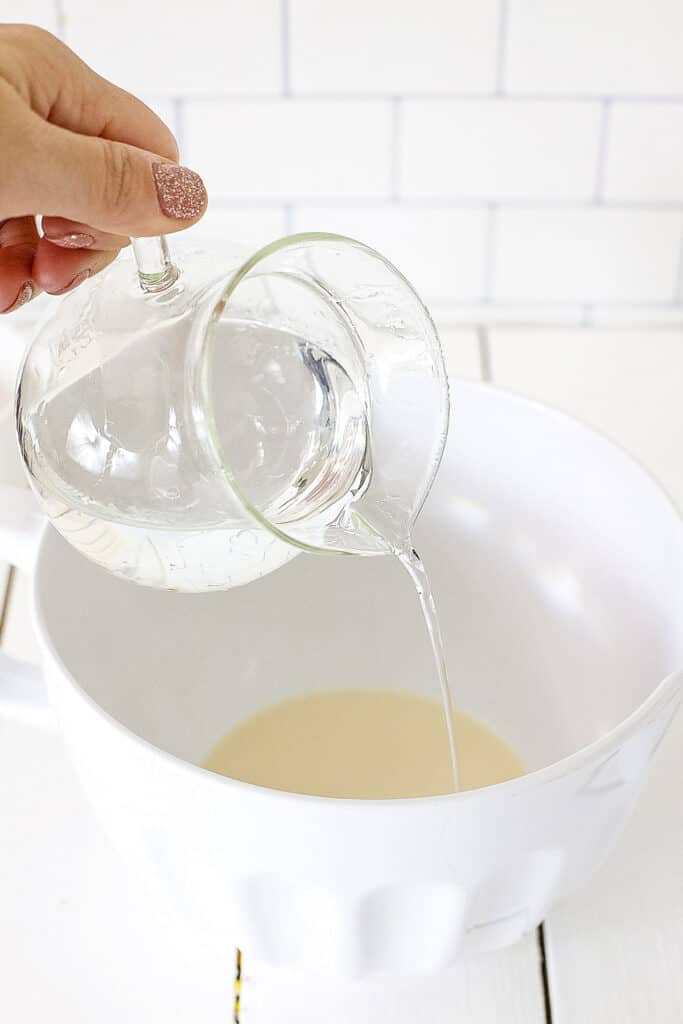 Pouring vodka into white mixing bowl