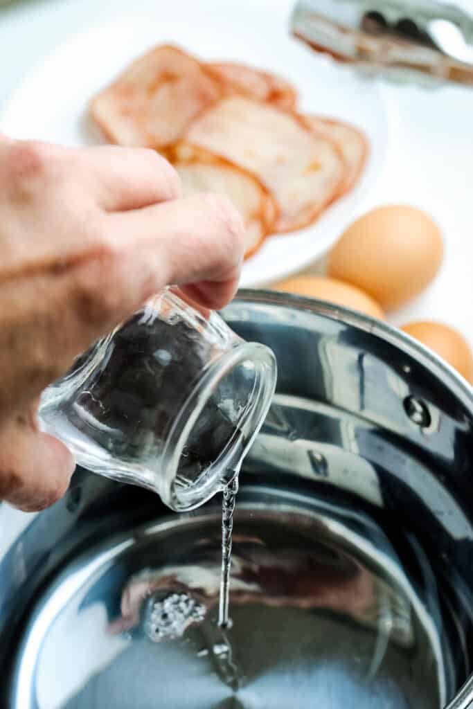 Pouring water into saucepan