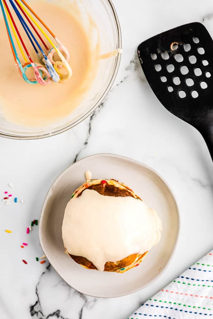 Overhead image of pancakes topped with vanilla frosting