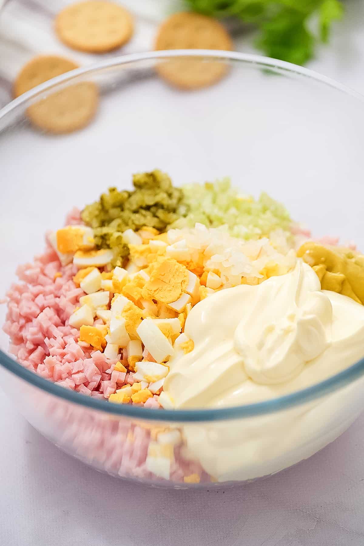 Bowl of diced ham, hard boiled eggs, celery, mayonnaise before mixing