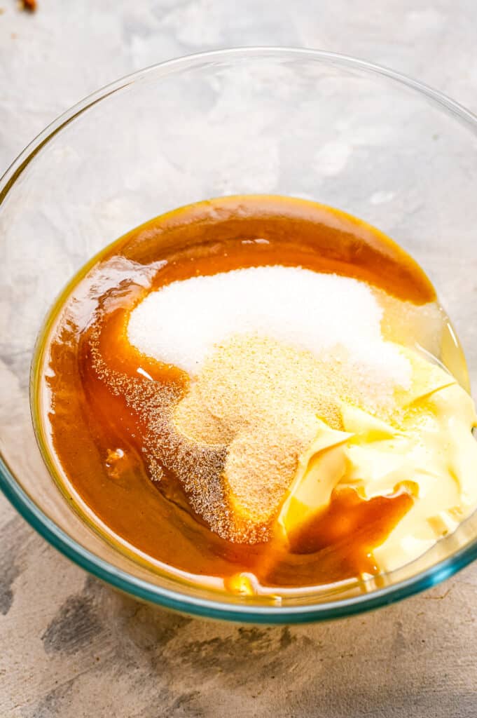 Glass bowl with ingredients in it to make pretzel dip before mixing