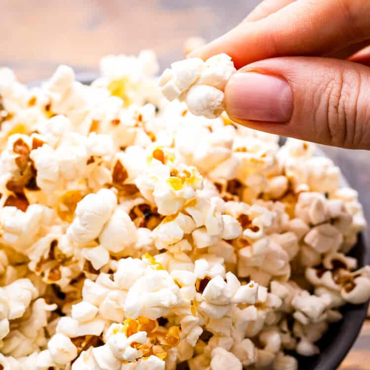 Hand taking popcorn out of a bowl