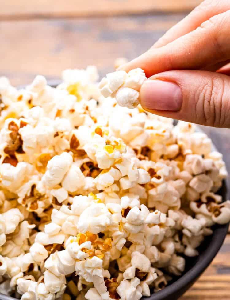 Hand taking popcorn out of a bowl