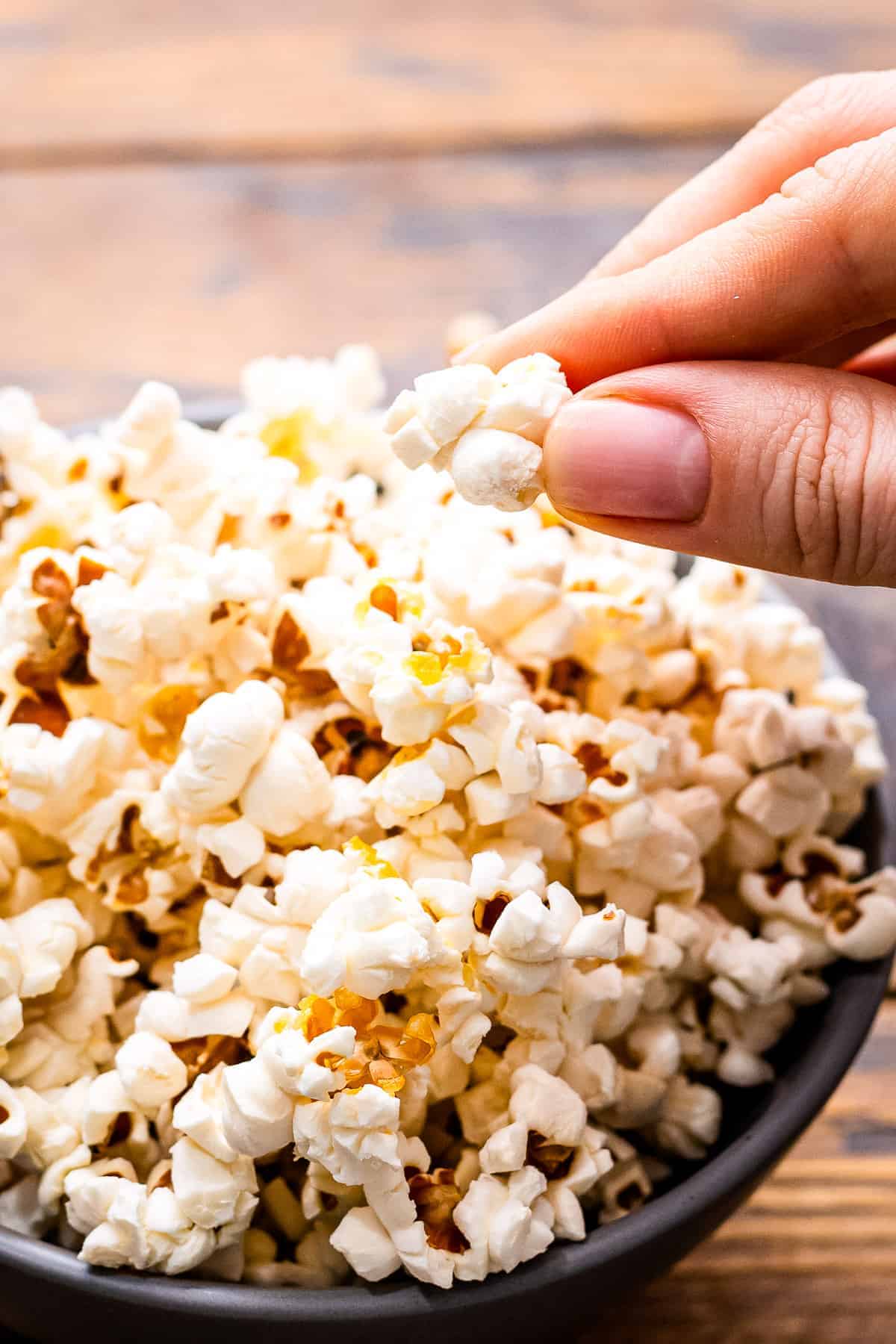 Hand taking popcorn out of a bowl