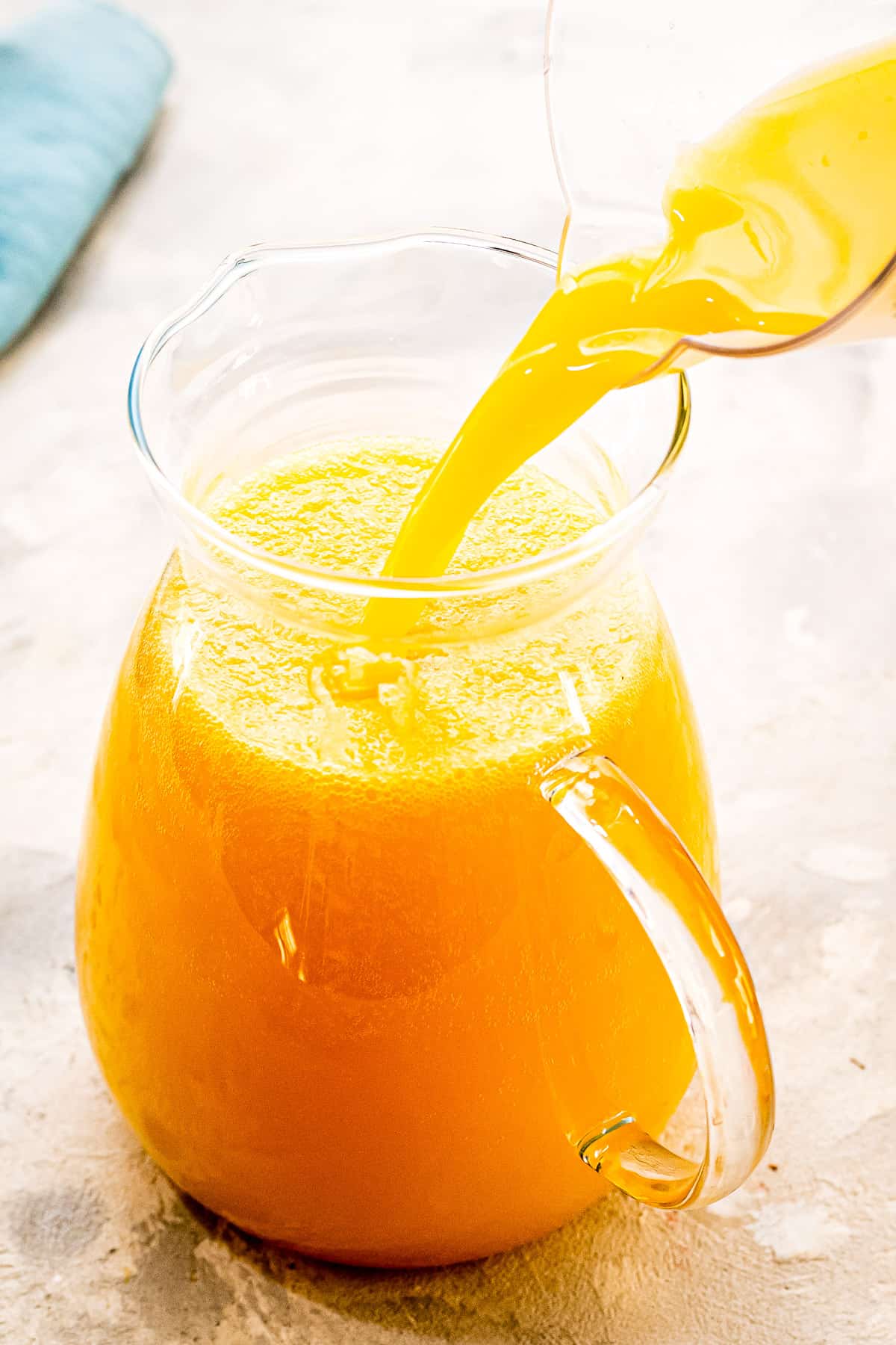 Pouring orange juice into a pitcher