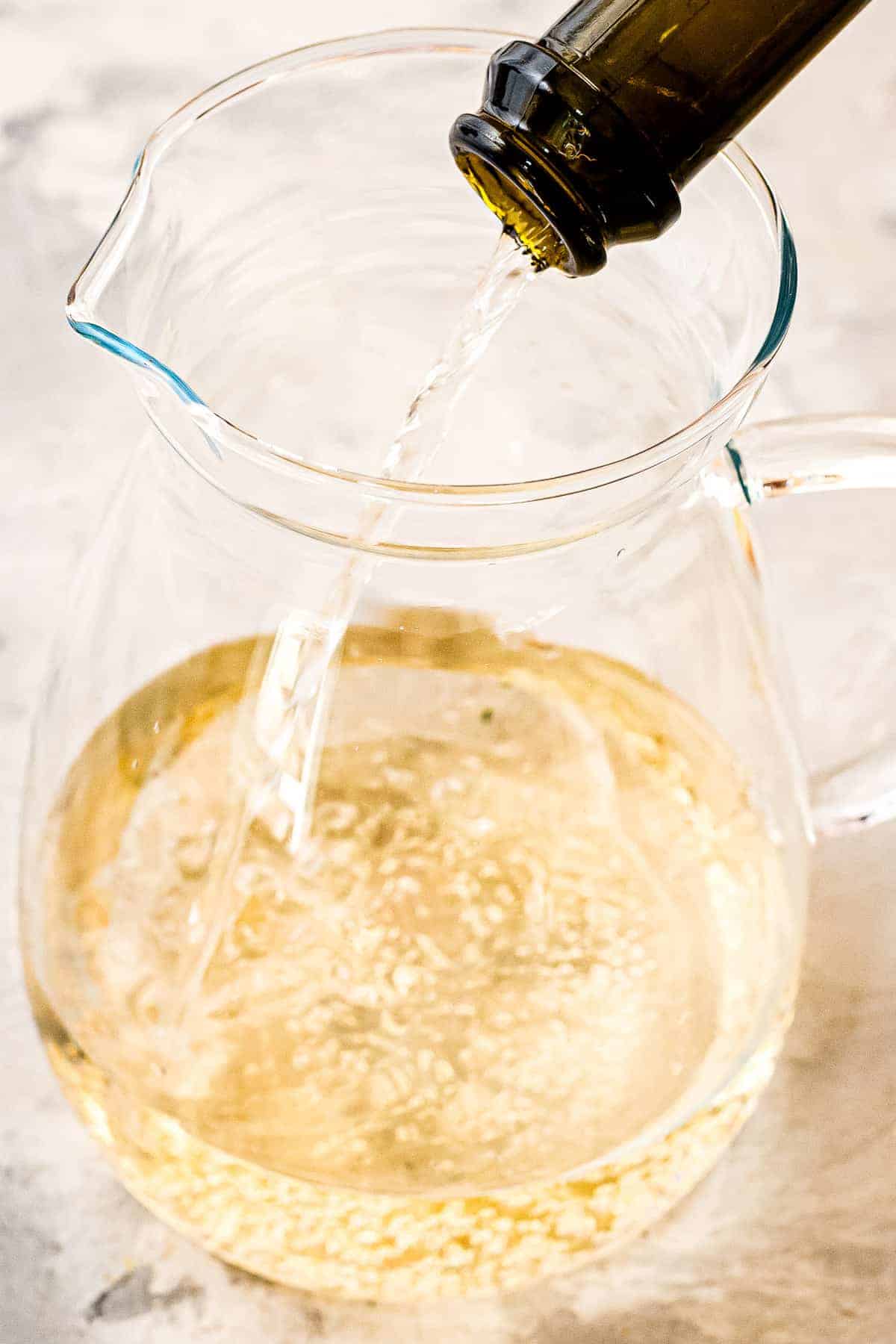Pouring sparkling wine into a pitcher