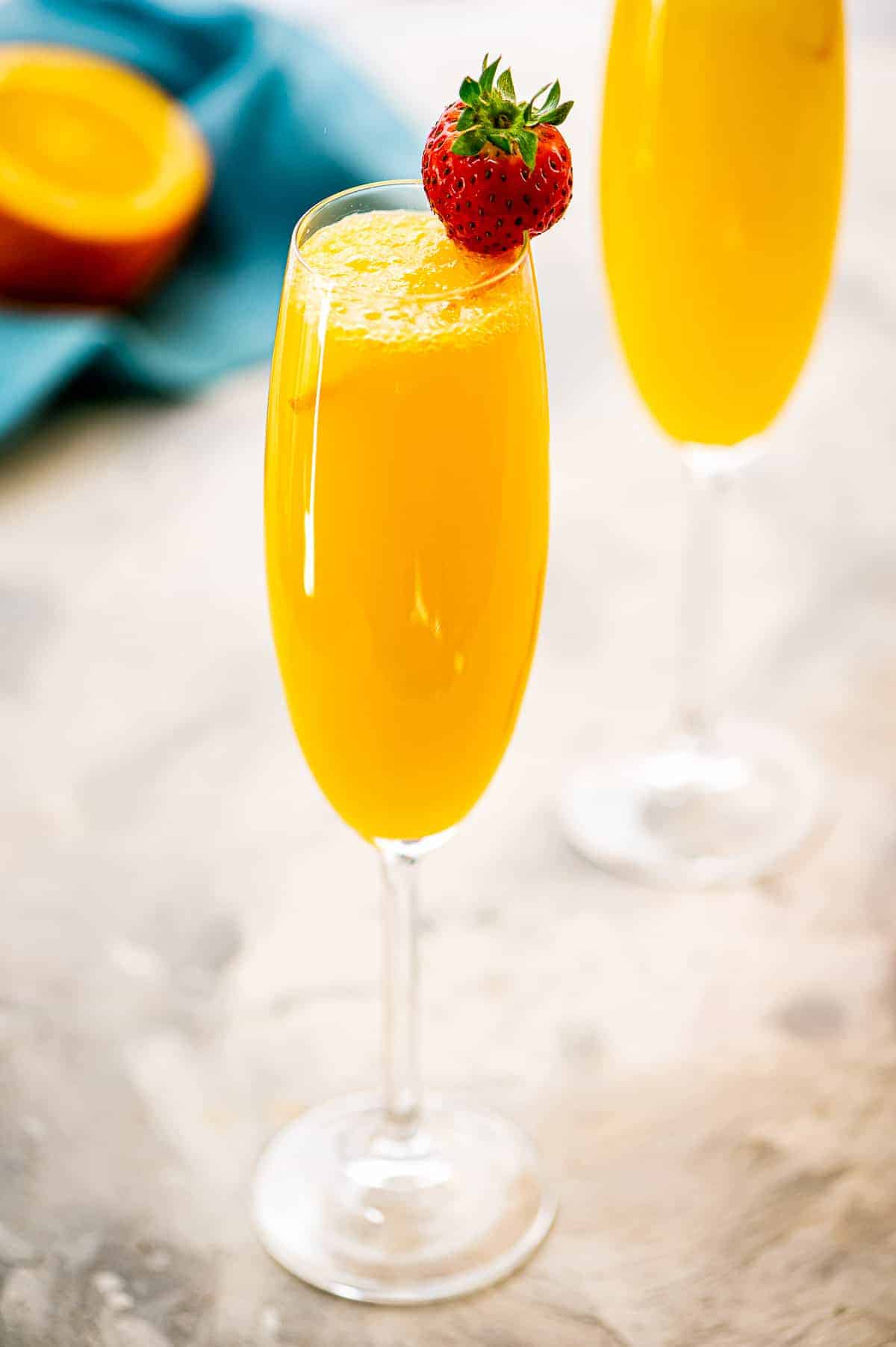 Champagne flute with a Mimosa in it and strawberry garnish