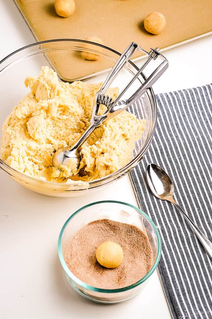 Rolling a ball of cookie dough in cinnamon sugar