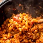 Spoon with Chili Mac over a pressure cooker