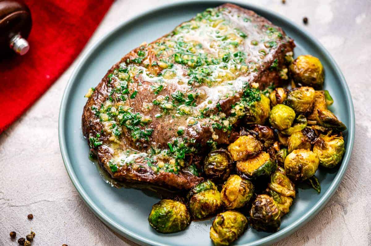 Blue plate with Air Fryer Steaks and a side brussels sprouts