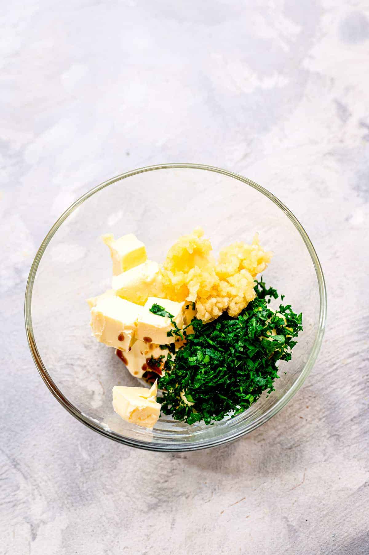 Glass bowl of Air Fryer Steaks with Garlic Butter Ingredients