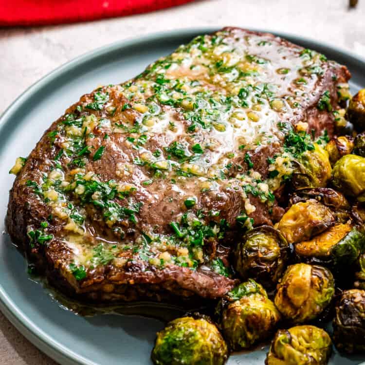Blue plate with Air Fryer Steaks with Garlic Butter and brussels sprouts