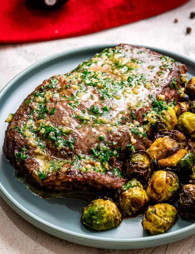 Blue plate with Air Fryer Steaks with Garlic Butter and brussels sprouts