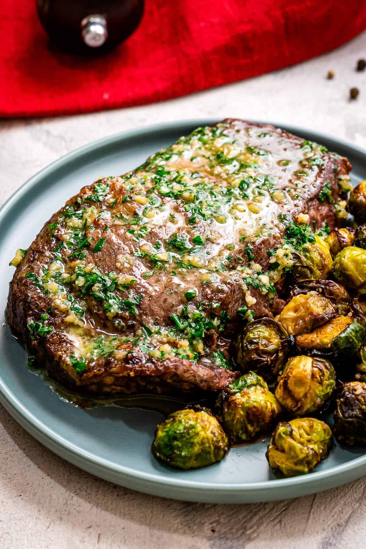 Blue plate with Air Fryer Steaks with Garlic Butter and brussels sprouts