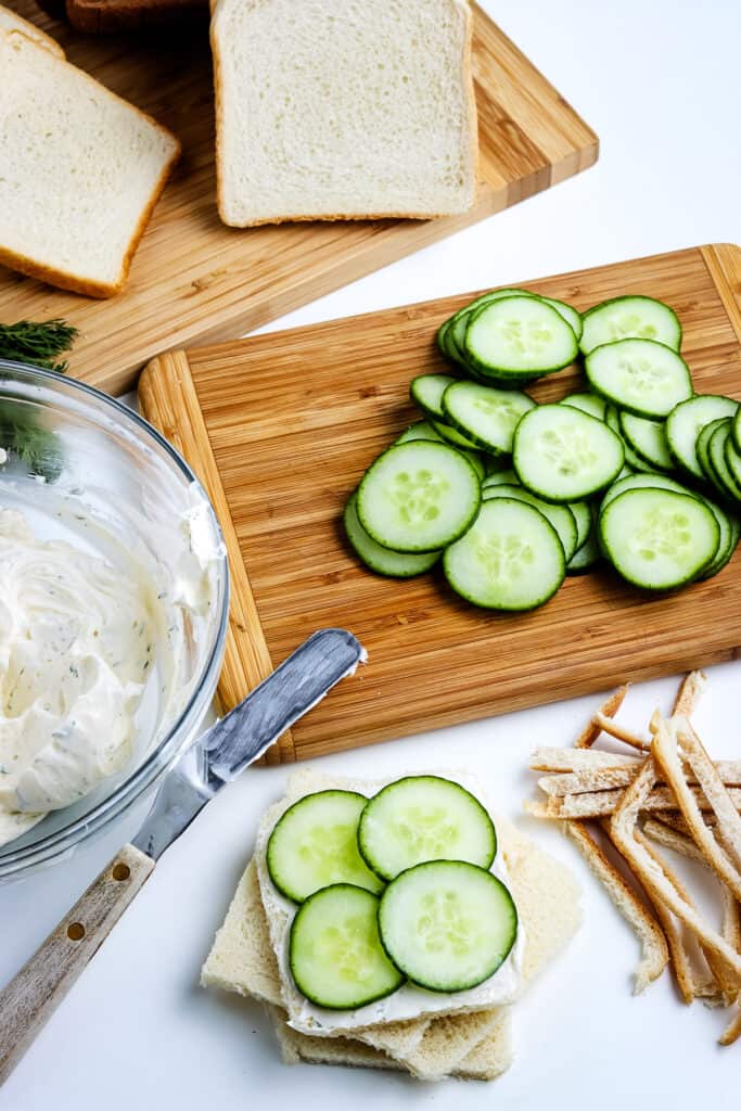 Bread slice topped with dill cream cheese spread and sliced cucumbers