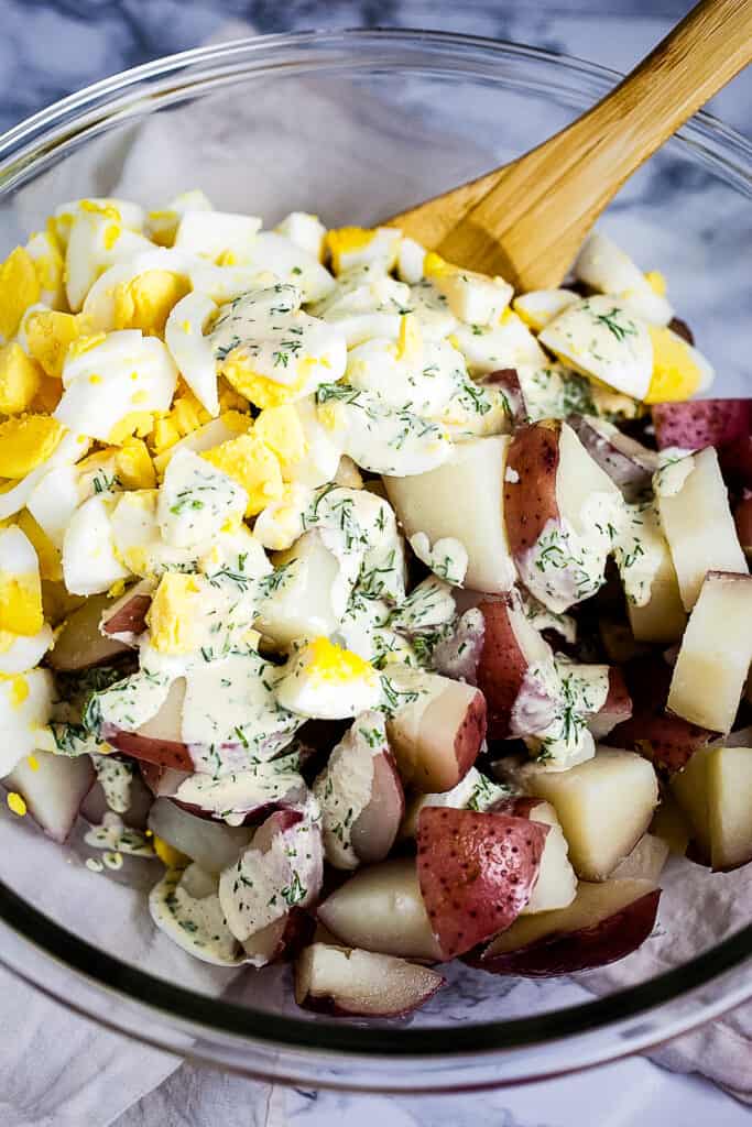 Glass bowl with ingredients for dill potato salad before mixing