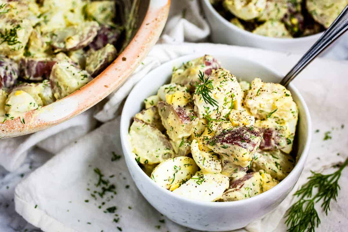 Small white bowl with dill potato salad