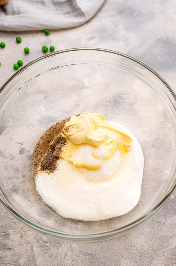 Ingredients in glass bowl for a sour cream and mayonnaise dressing