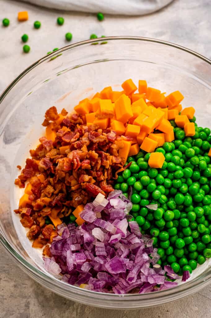 Ingredients for pea salad before mixing in glass bowl