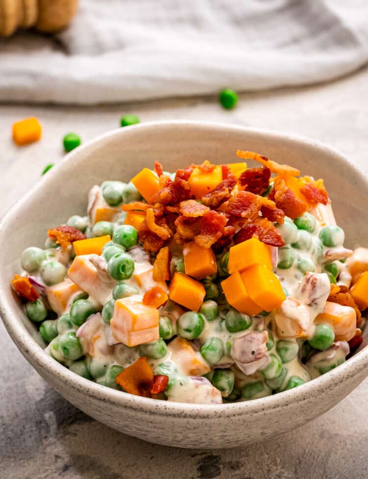 Pea Salad in a bowl topped with crumbled bacon