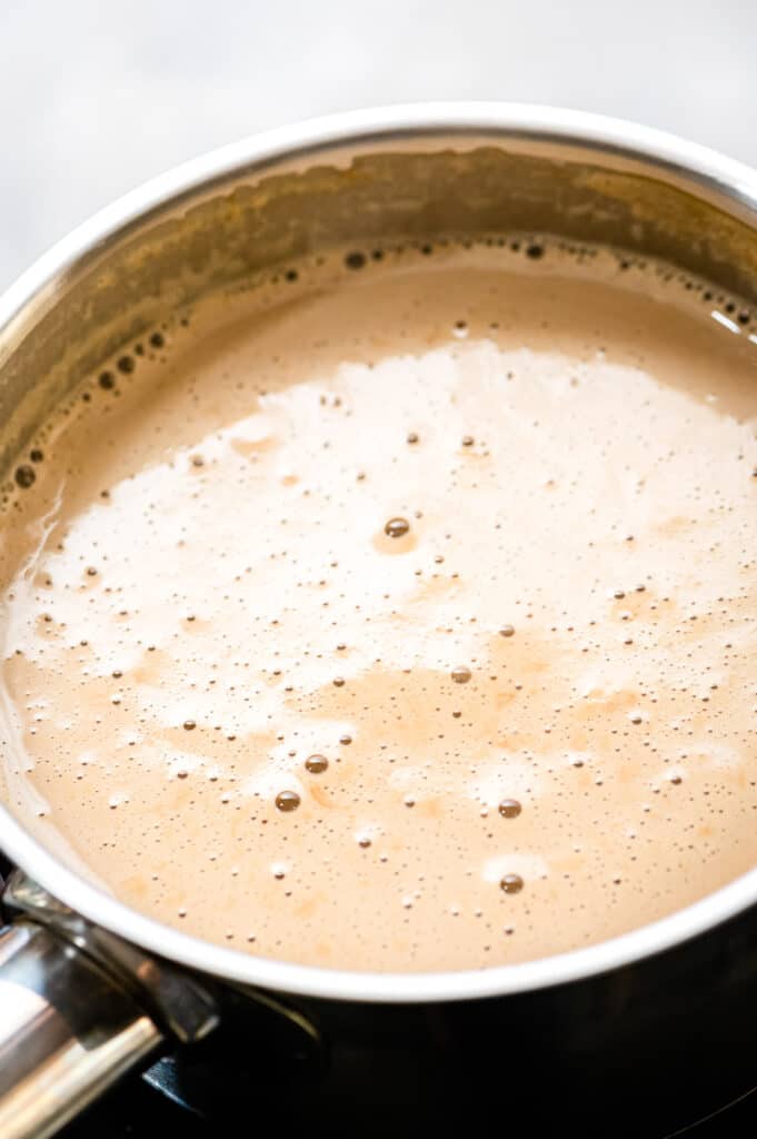 Saucepan with milk, extracts, brown sugar boiling