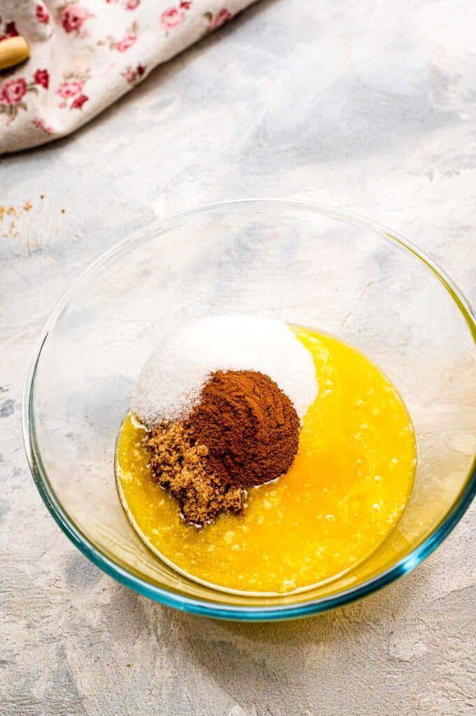 Glass bowl with melted butter, sugar, cinnamon and brown sugar